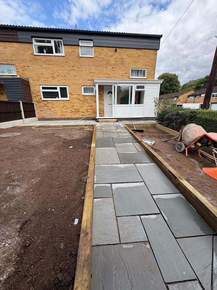 Before: bare topsoil either side of a newly laid slab path