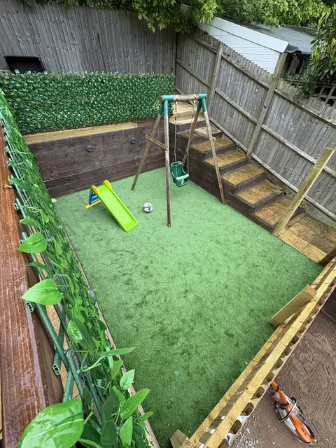 A picket fence and sleeper steps around a play area