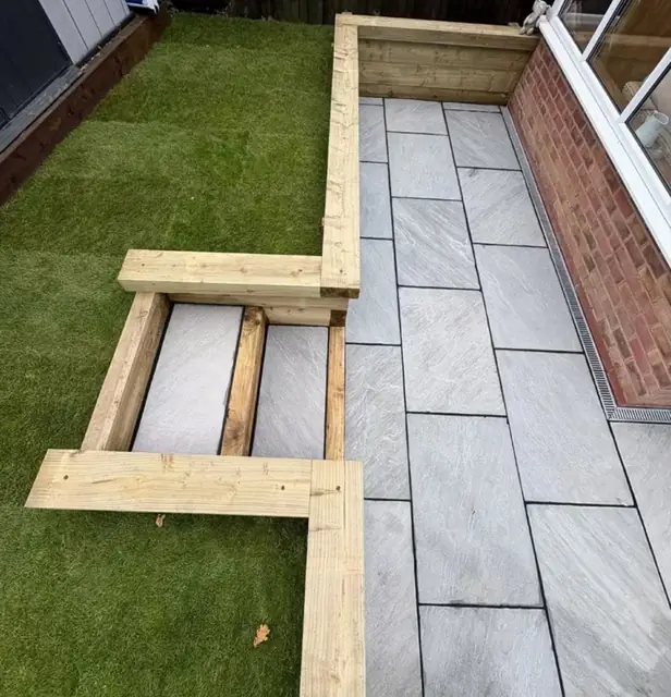 A narrow slab path with new timber edging set into a lawn
