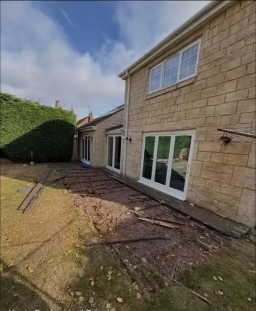 A sandstone path laid along the back of a stone faced house