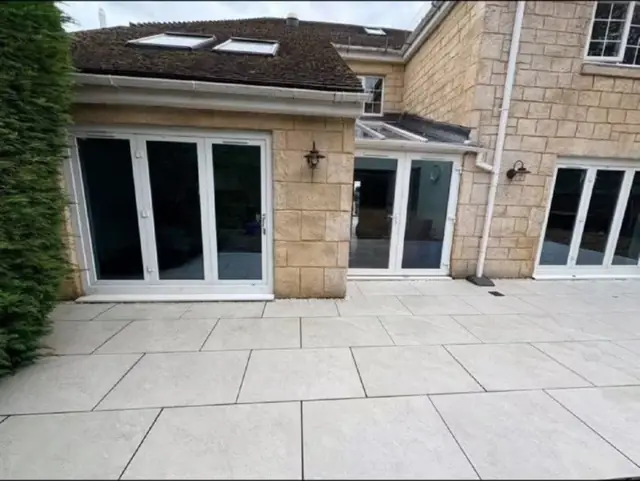 Pale porcelain paving laid outside a set of French doors
