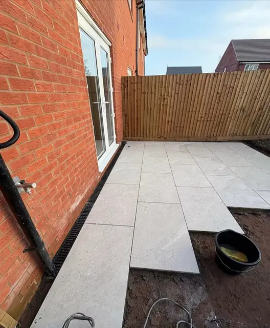 An L shaped white porcelain patio around the back of a house