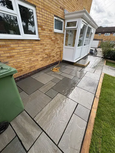 Mixed grey sandstone paving wrapping around a conservatory