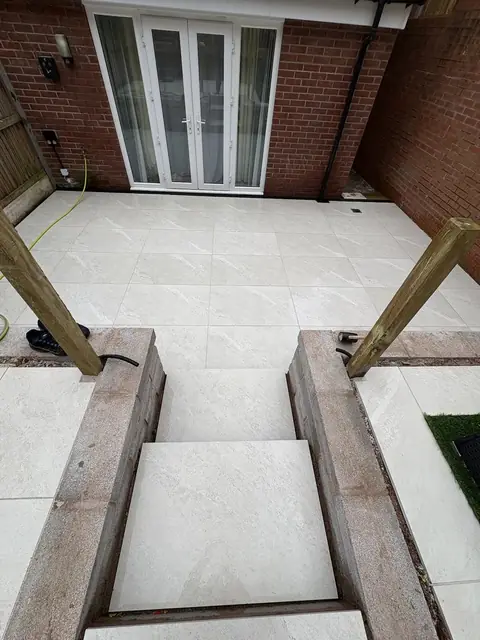 A pale porcelain patio and steps outside a set of French doors